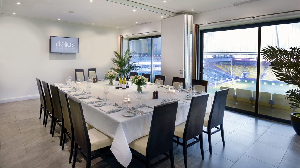 Image of a dining table set for 14 inside the stadium overlooking the pitch